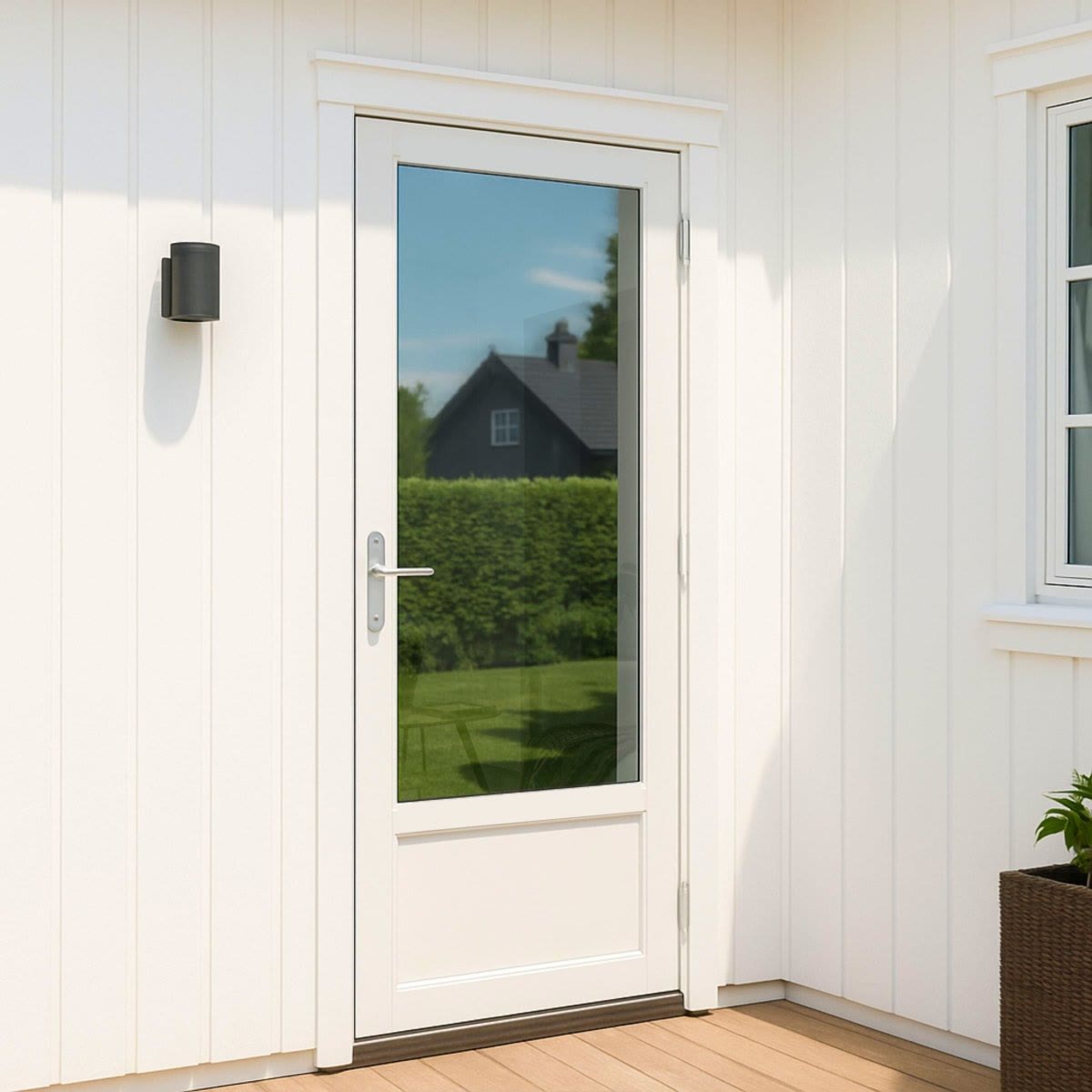 Altandörr med reflekterande fönsterfilm som speglar gräsmattan och huset utanför