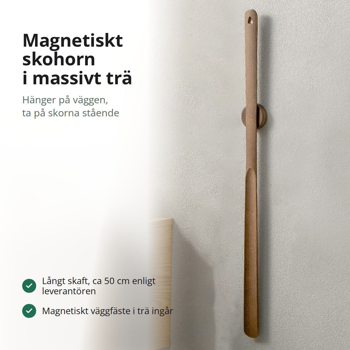 Magnetiskt skohorn i valnöt som hänger på sitt väggfäste, med texten Magnetiskt skohorn i massivt trä