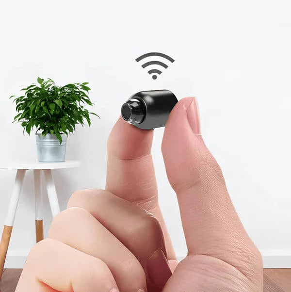 Mini wifi-kameran hålls mellan tummen och pekfingret