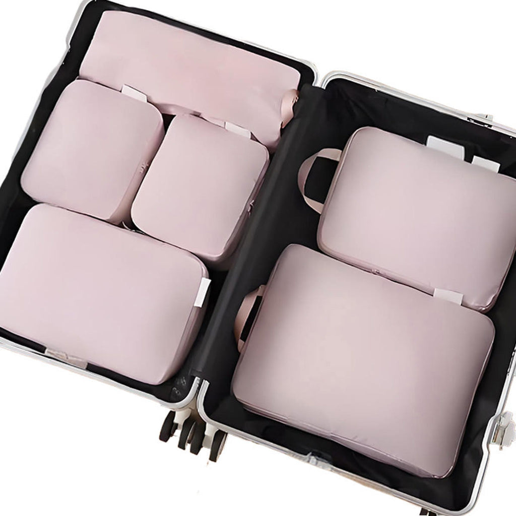 Packpåsar i rosa: sex påsar lagda platt i en öppen resväska