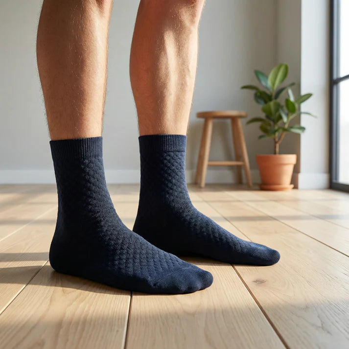 Man i mörkblå bambusockor står på trägolv